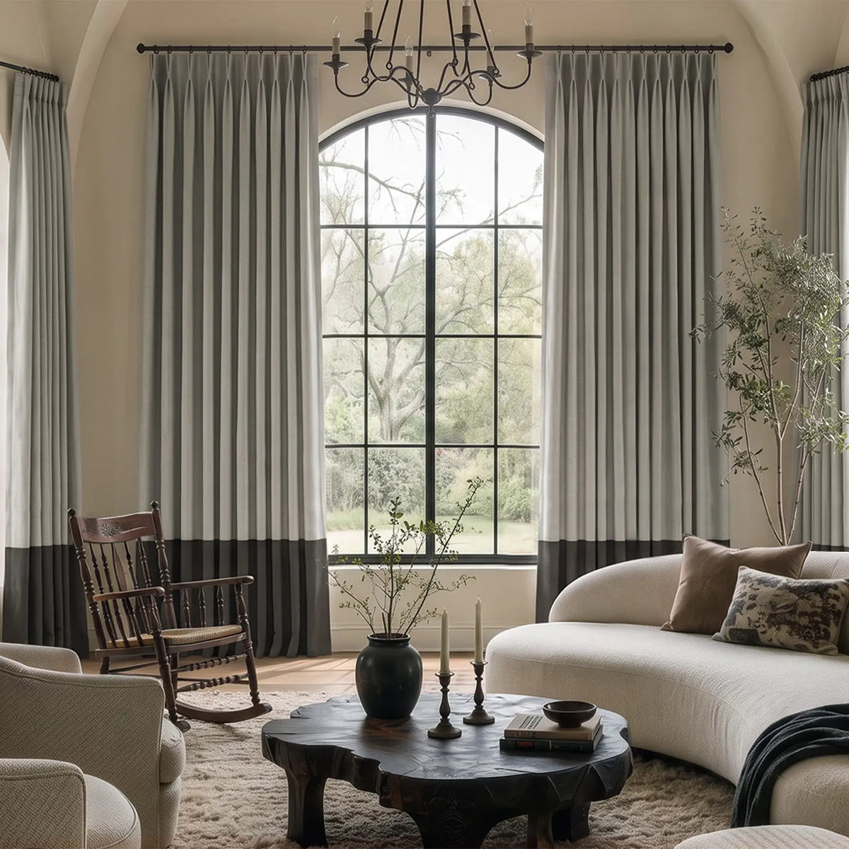 Two-tone pinch pleat curtains with a contrasting bottom border at a bright window, shown in a closer material view.