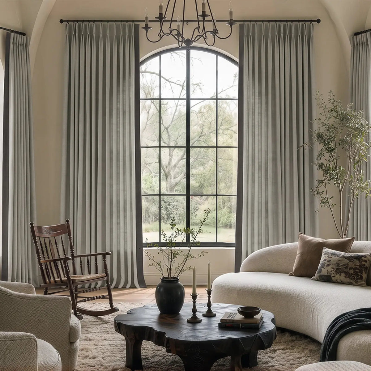 Two-tone pinch pleat curtains with a contrasting leading-edge border at a bright window, shown in a closer material view.