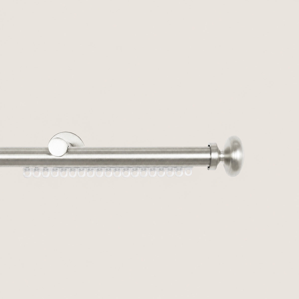 Brushed Silver Koda curtain rod with carrier track and flared decorative finial.