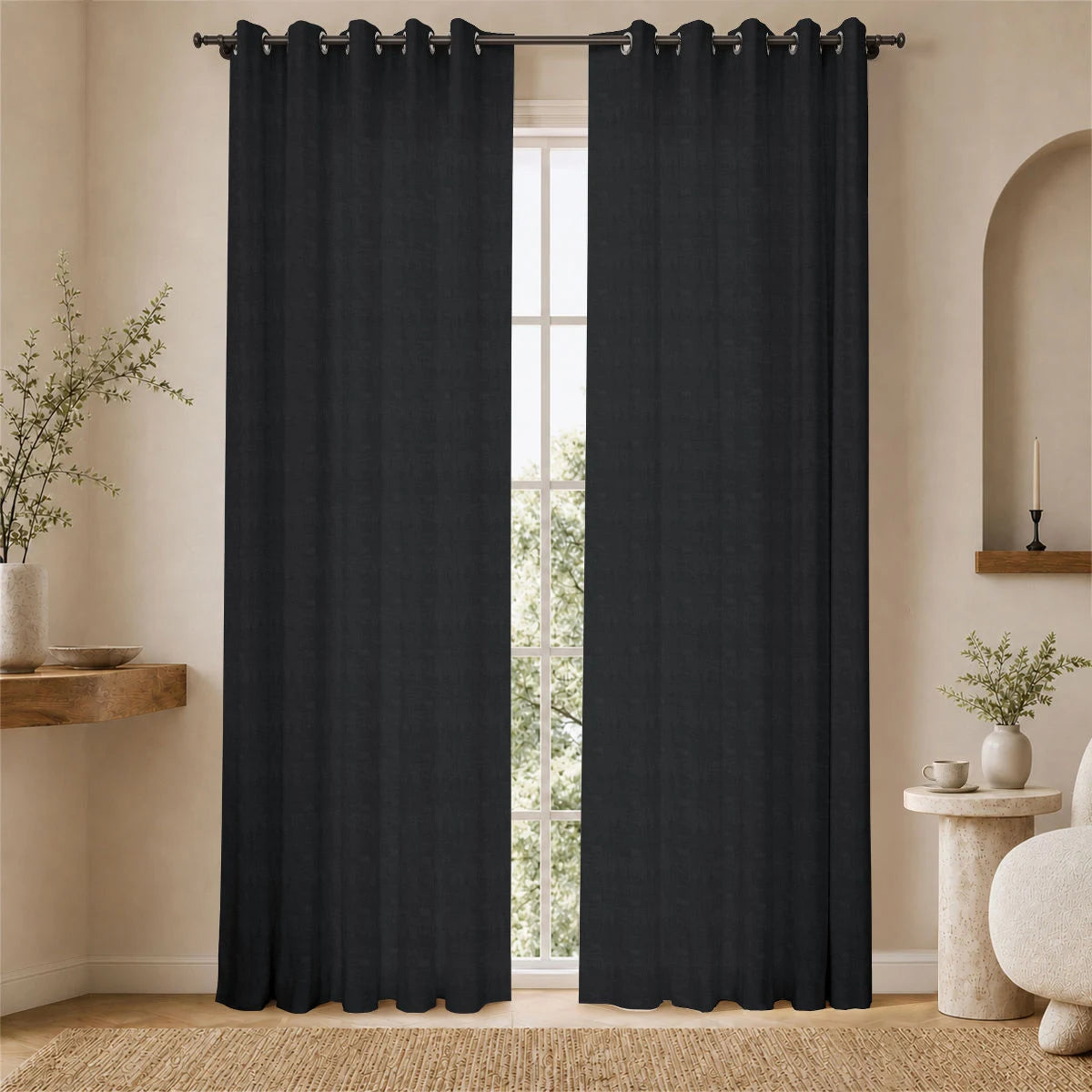 Charcoal gray aria fabric grommet curtains framing a bright window in a softly lit neutral room.
