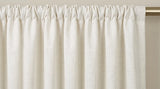 Close-up of an ivory rod pocket curtain gathered along a brass rod.