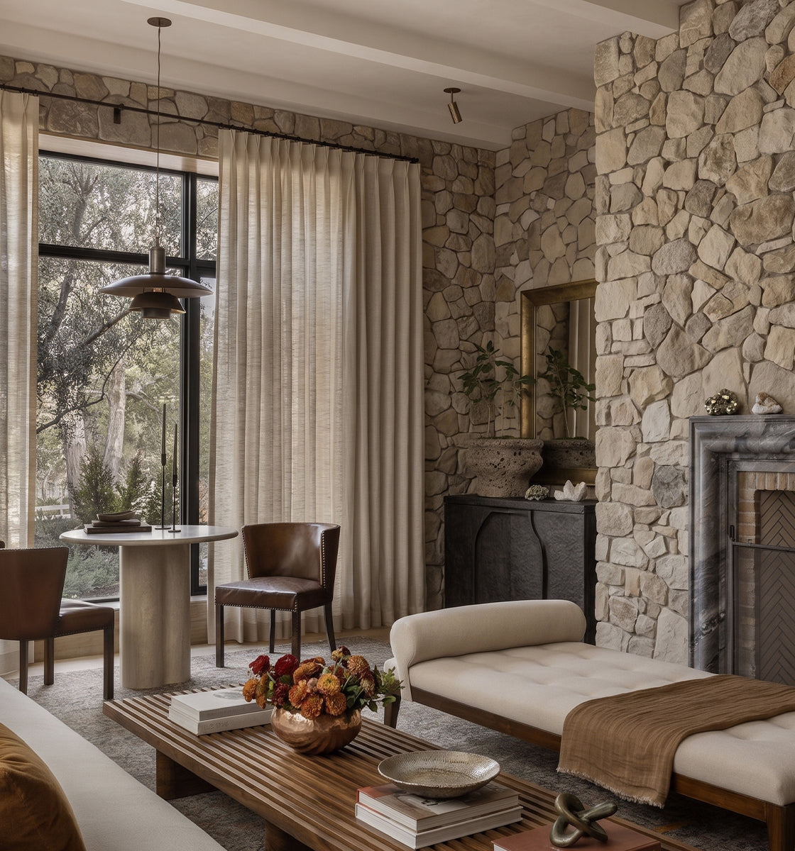 Neutral living room with floor-length curtains framing large windows.