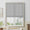 Gray woven fabric flat Roman shade partially lowered over a white framed window